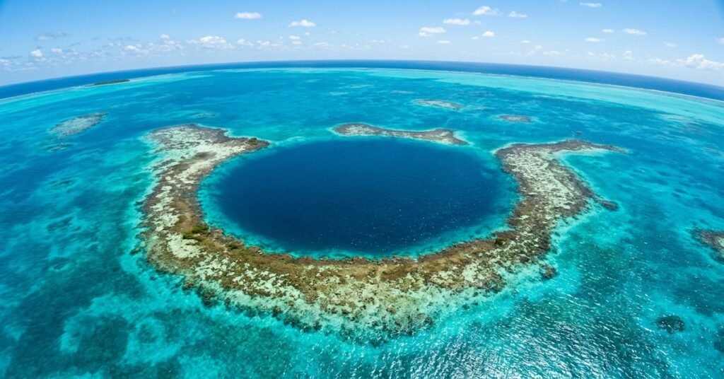 Aerial view of the Great Blue Hole in Belize surrounded by turquoise water